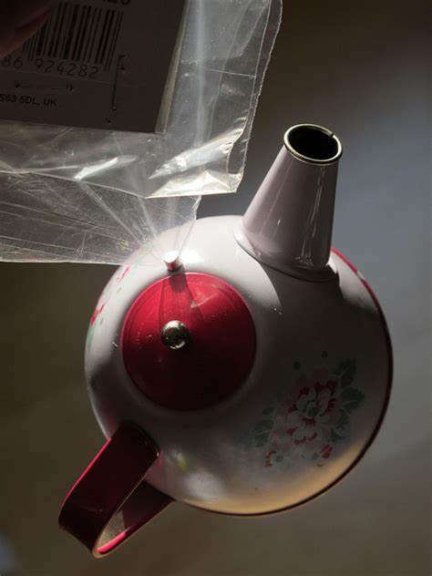Ein kleiner Neodym Magnet hält eine Teekanne aus Metall in der Luft, obwohl er in einer Plastiktüte steckt.