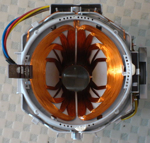 Ein technisches Gebilde aus Spule und offenem Eisenkern, sowie einigen Kabeln ist zu sehen - ein Elektromagnet.